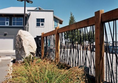 Steel and wood railing with landscaped boulders