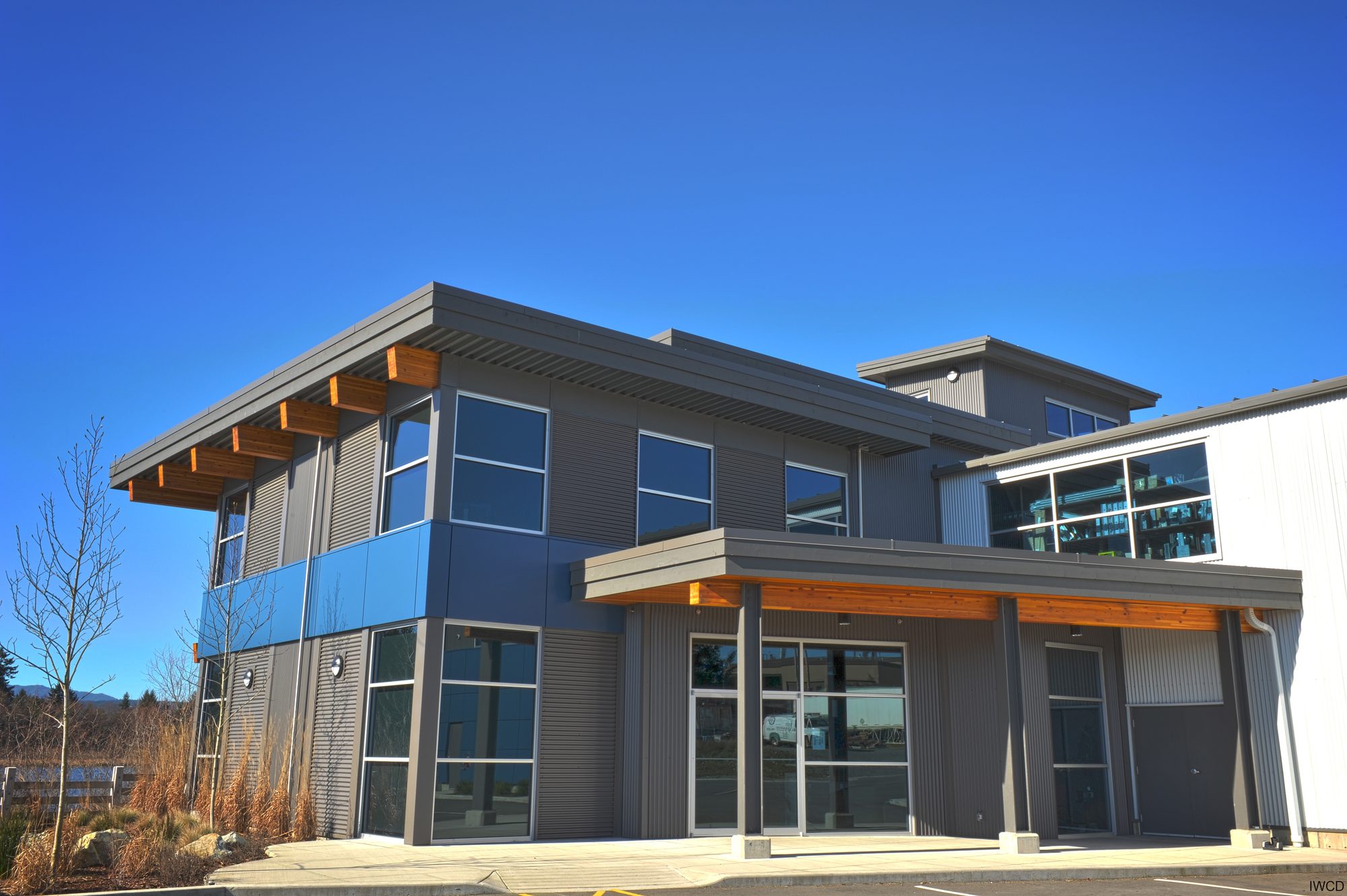 Two-storey building with a timber roof and blue glazing