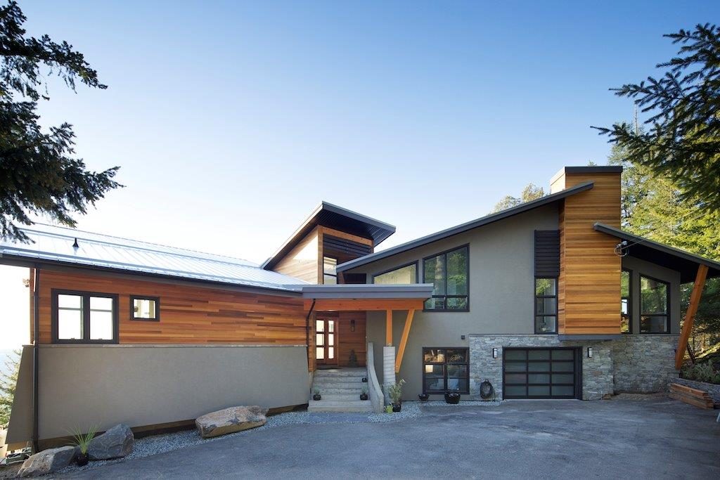 Contemporary house with wood siding, stone and a shed roof