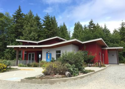 Single-storey building with red cladding and a gravel forecourt