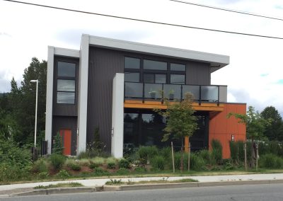 Two-storey commercial building with orange panels and balconies
