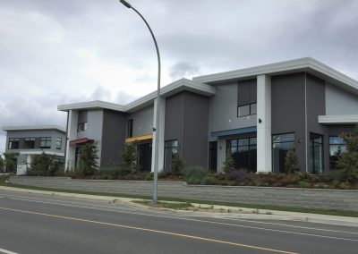 Row of grey commercial buildings along a street
