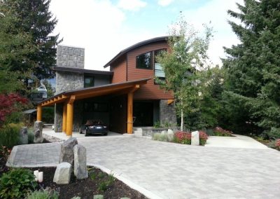 House with a curved roof and stone driveway