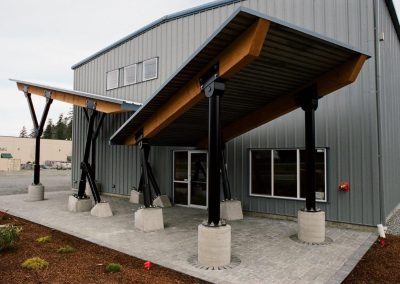 Timber entrance canopy on a metal-clad building