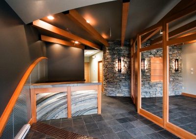 Lobby with timber beams, stone wall and glass doors