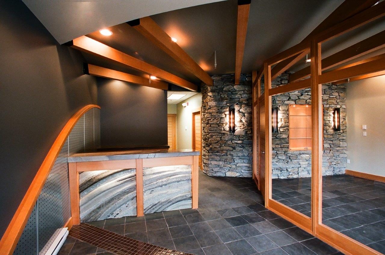 Lobby with timber beams, stone wall and glass doors