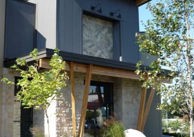Narrow two-storey building with stone and timber posts