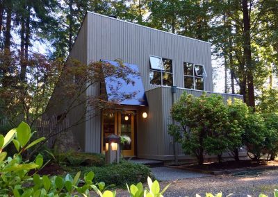 Building with grey siding among trees