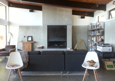 Living room with a concrete fireplace wall