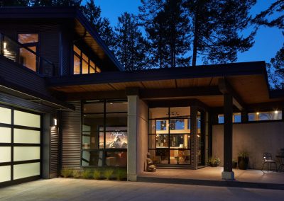 House with a glass garage door, lit at dusk